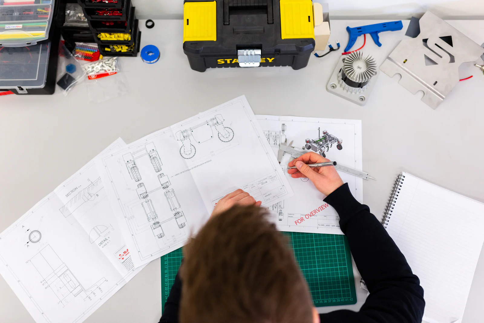 Engineer reviewing technical drawings beside a toolbox