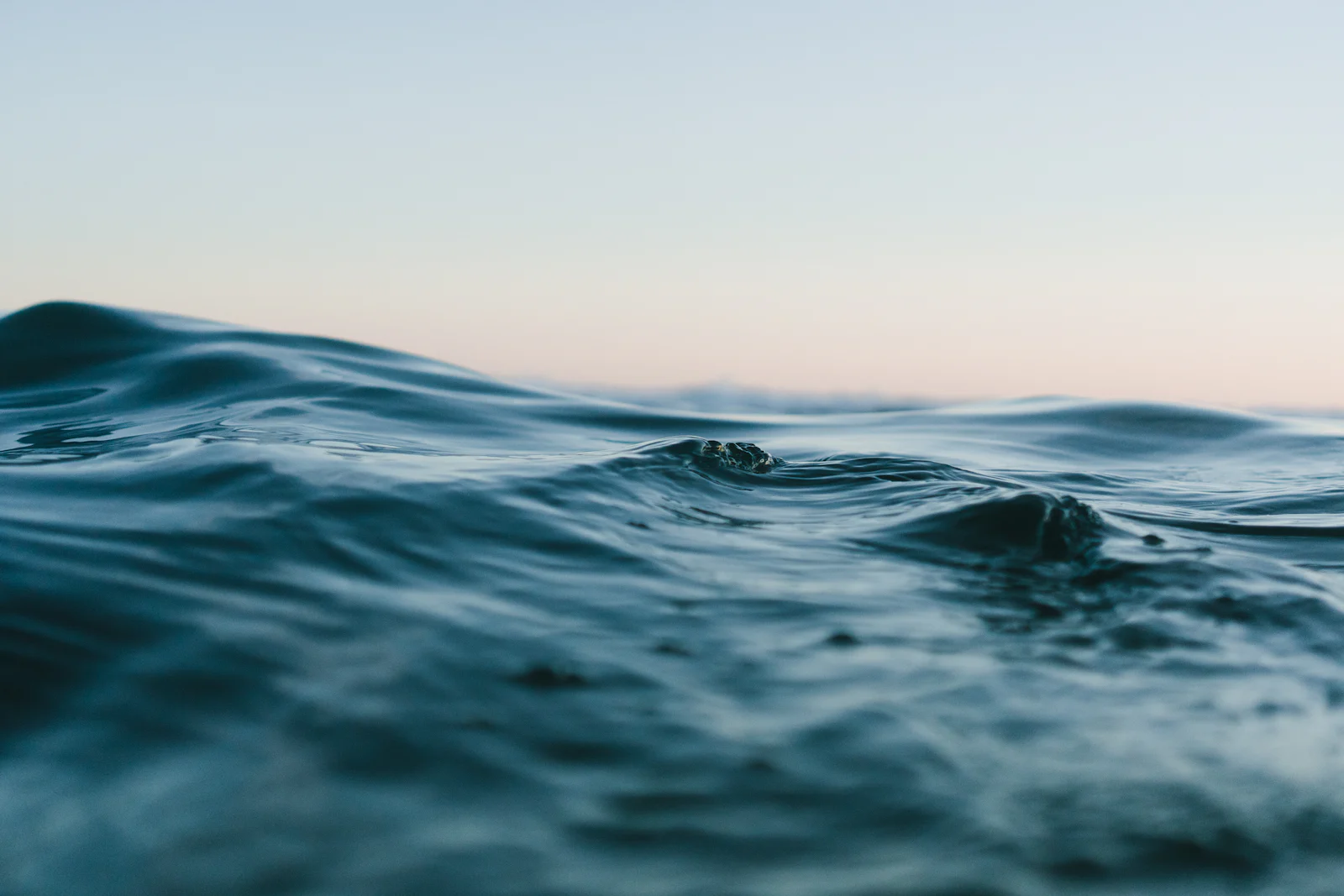Ocean waves under a pale morning sky