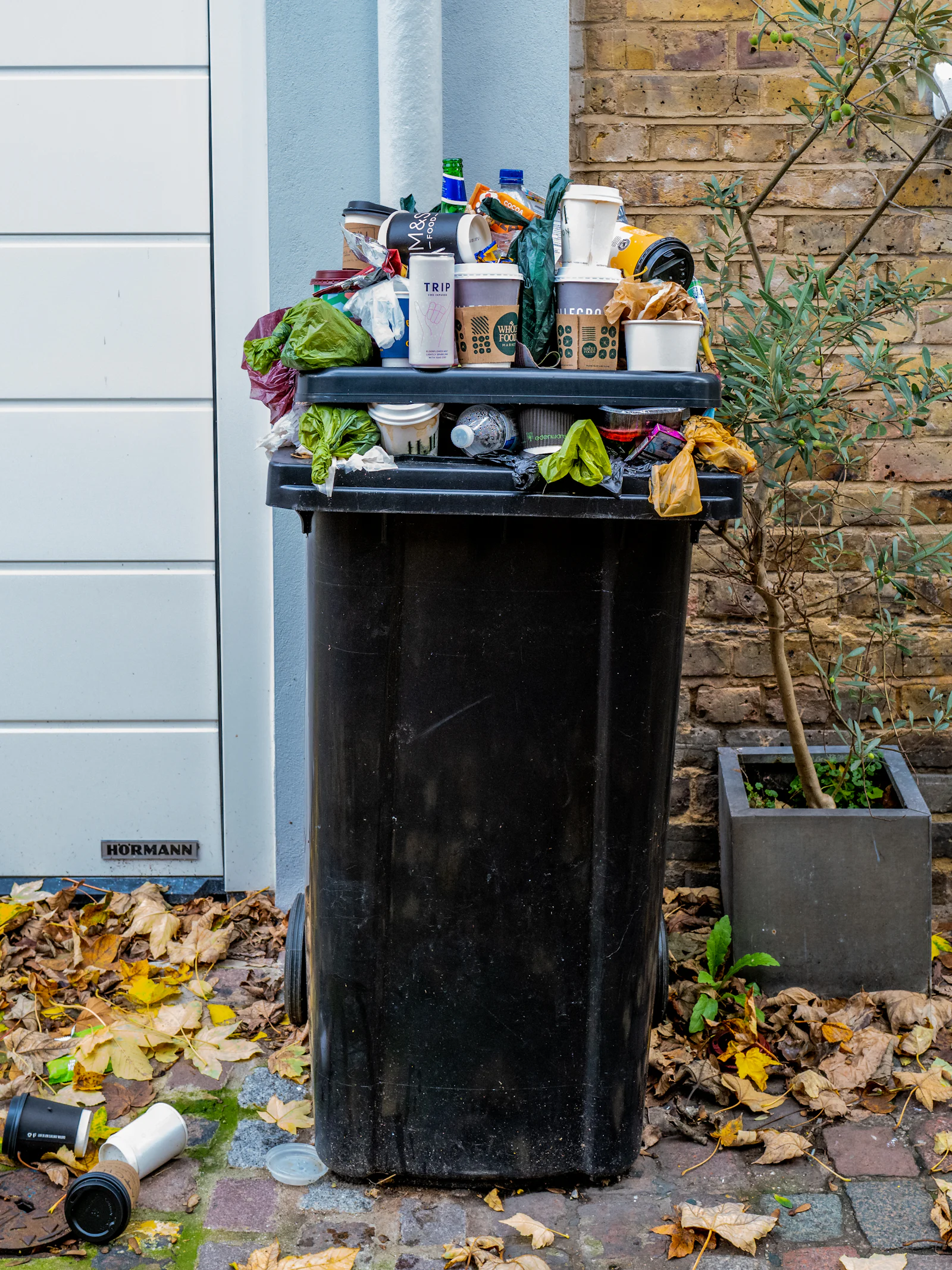 Overfilled wheelie bin awaiting collection